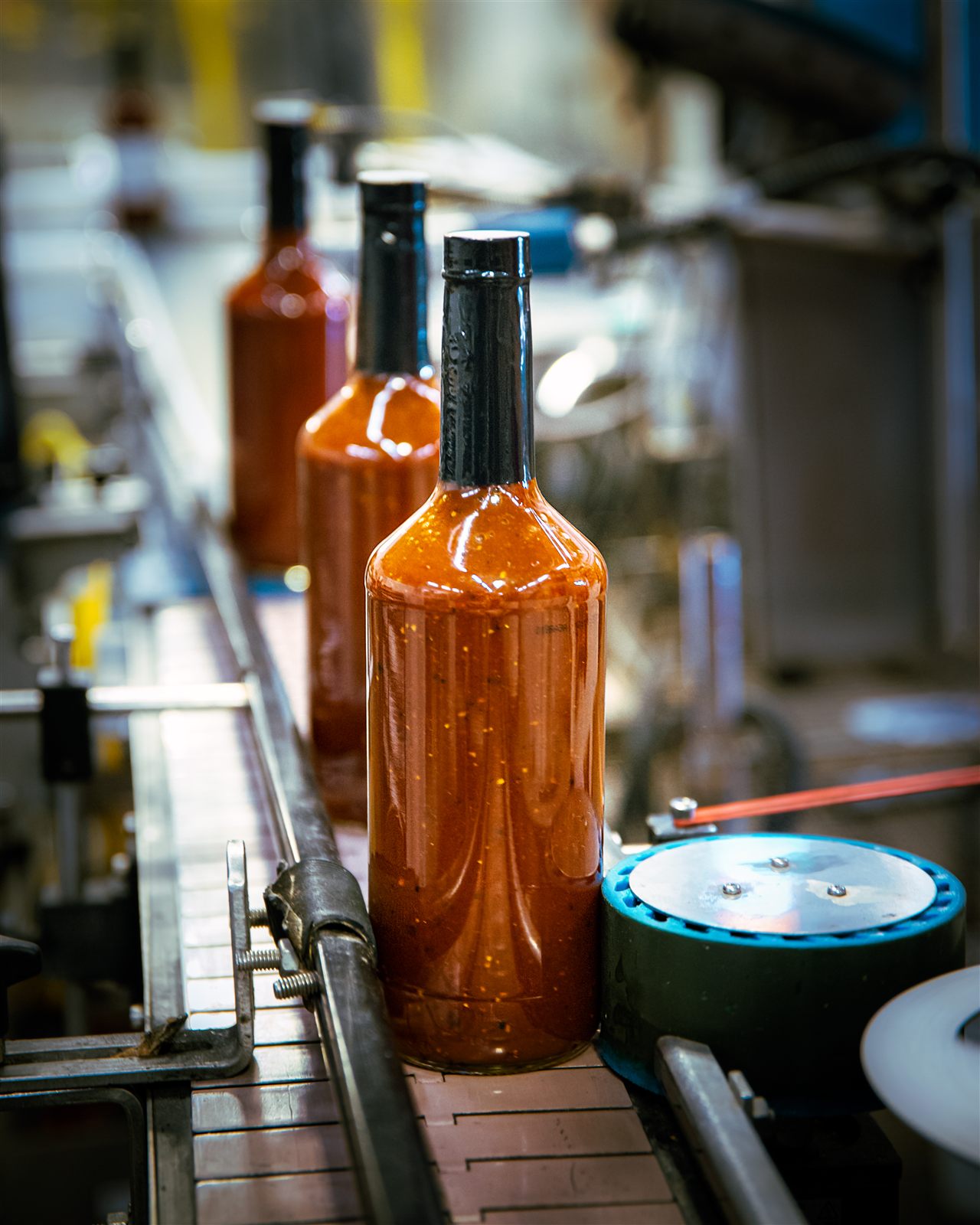 A finished sauce bottle moving down the Creative Foodworks production line